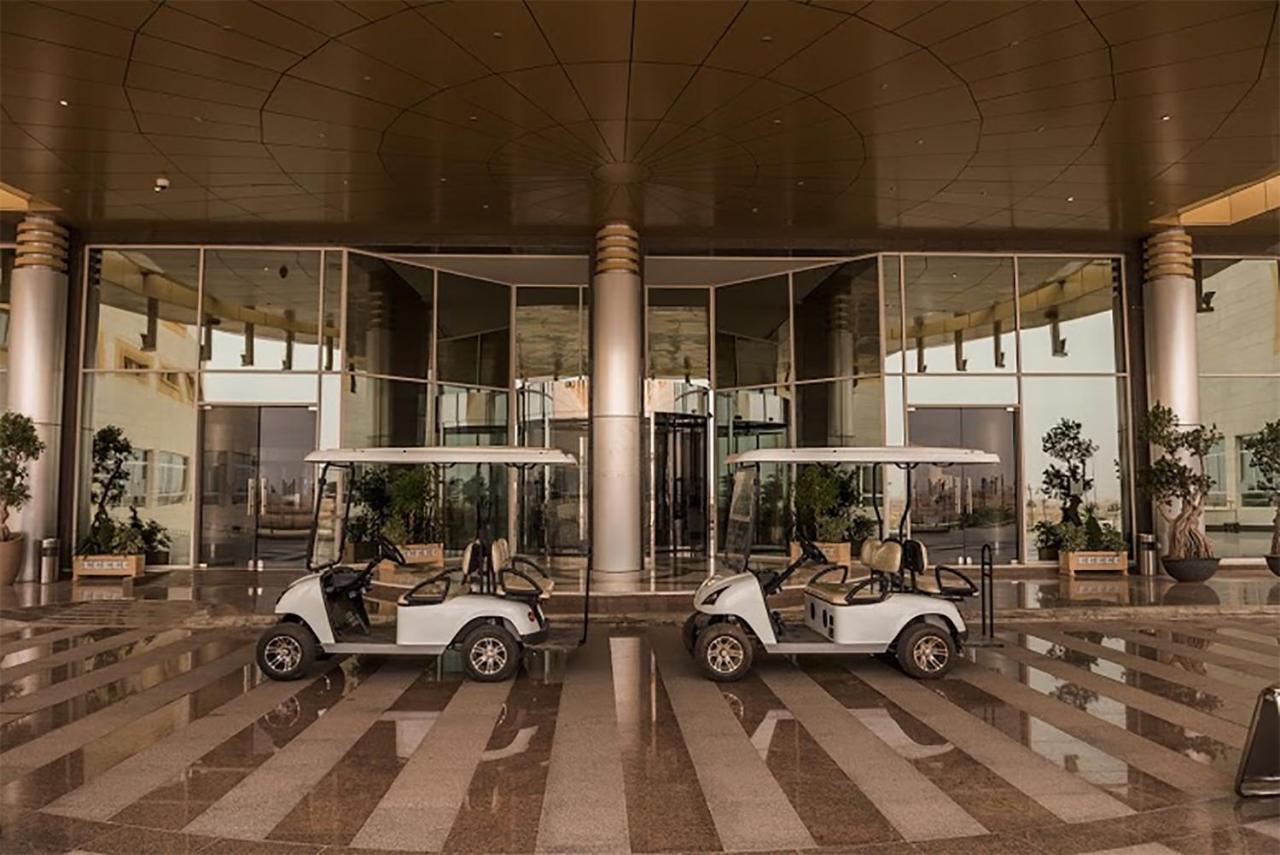 Millennium Hail Hotel Extérieur photo Golf carts at the entrance of the hotel